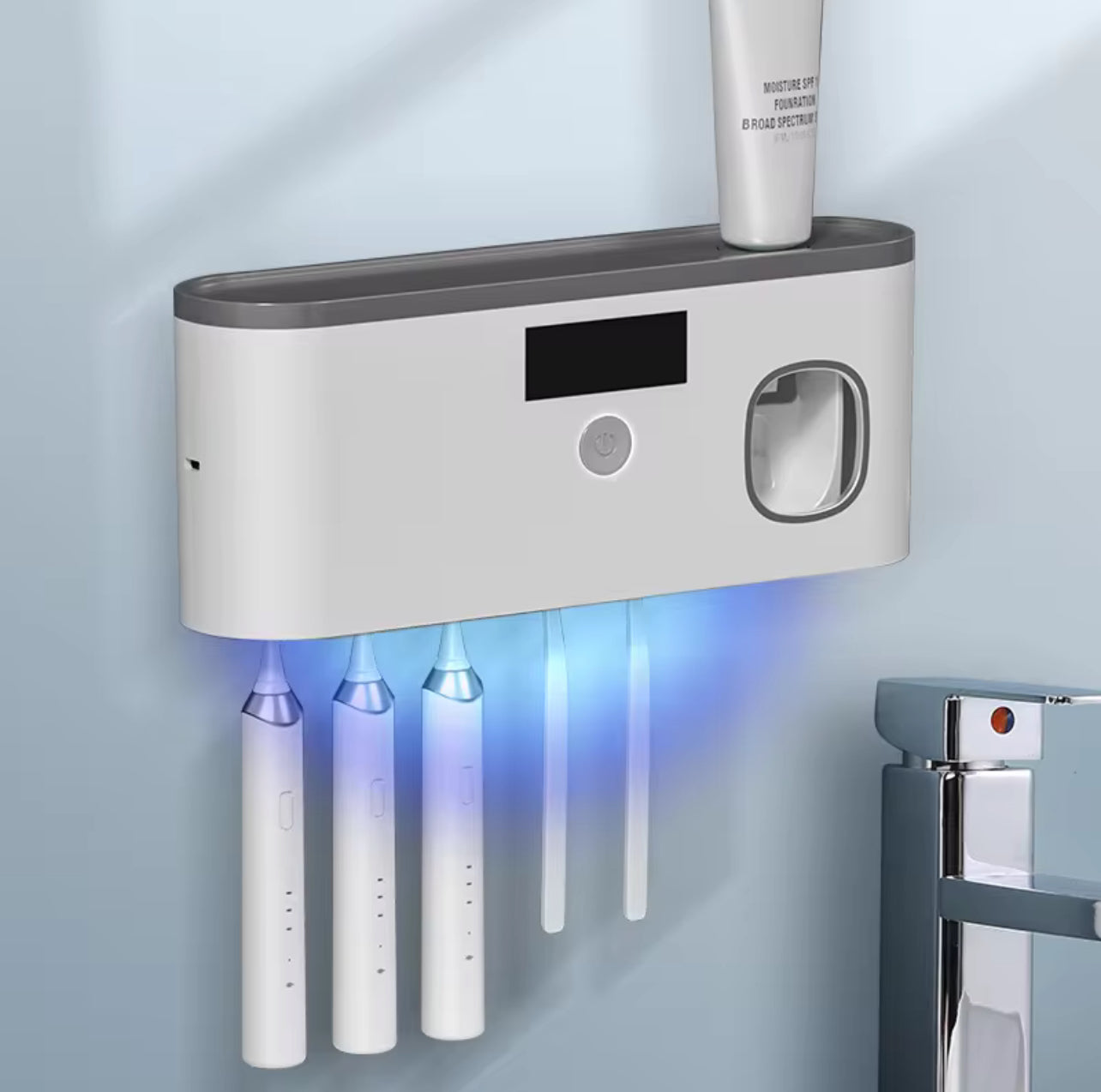 Wall-mounted electric toothbrush holder with multiple toothbrushes and a digital display.