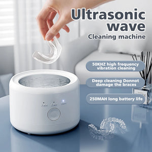 Ultrasonic wave cleaning machine with a hand placing a clear dental device into it, set against a blurred indoor background.